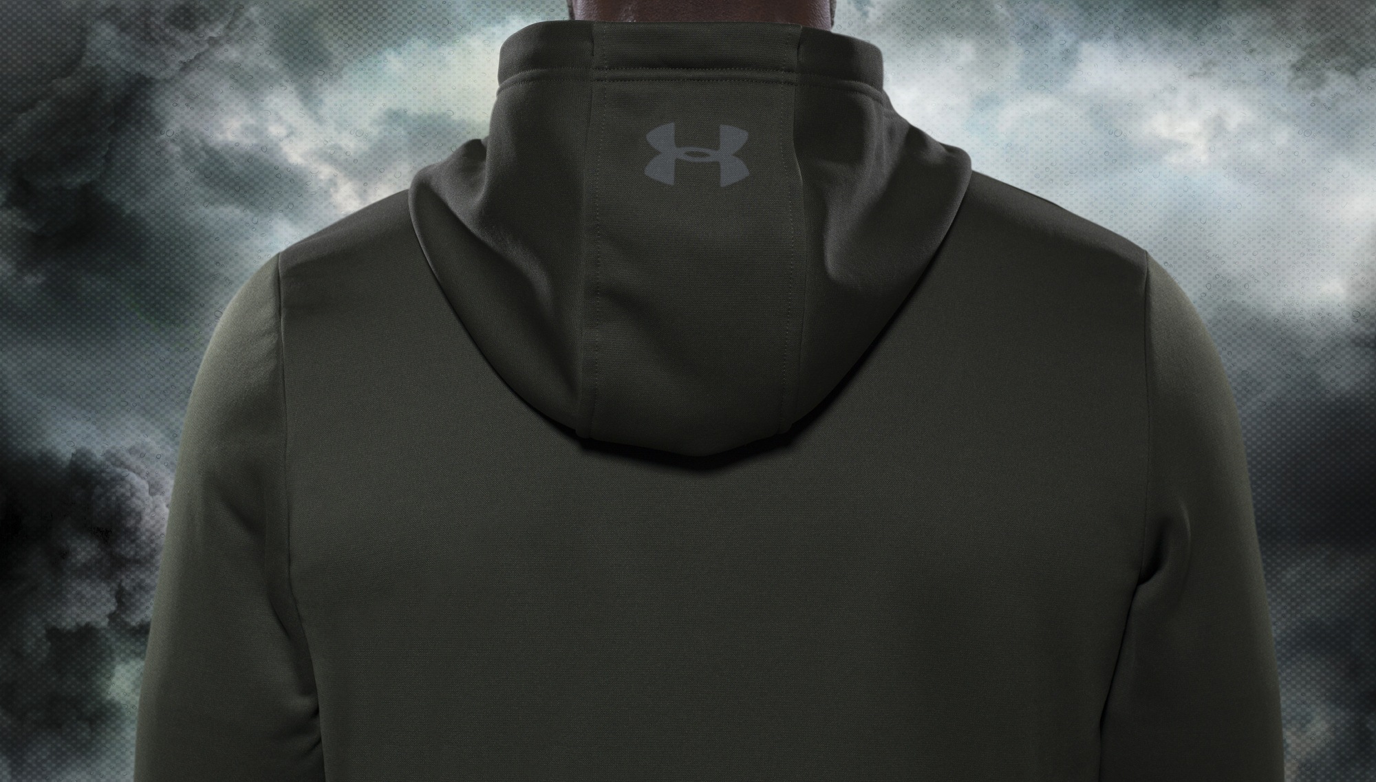 back view of an olive green under armour track top on a stormy background