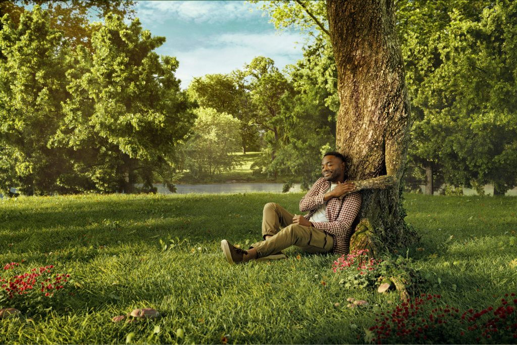 Patients and purpose. Park, mental health. man leaning on tree. Nature, calming.